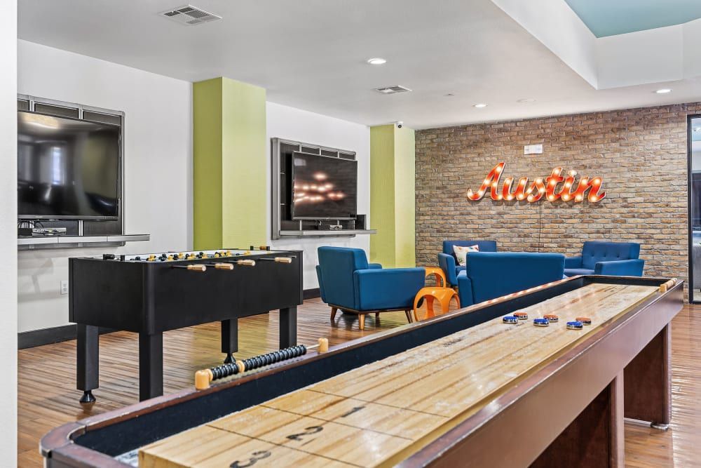 A shuffleboard table in the middle of the community game room at Regents West at 24th in Austin, TX, near West Campus.