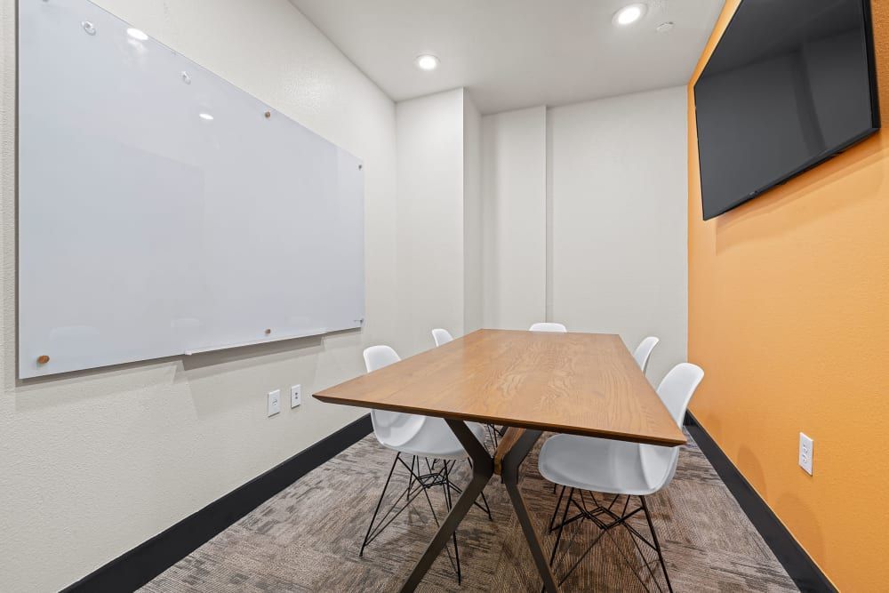 Private study room with a table and chairs and a whiteboard at Regents West at 24th in Austin, TX, near West Campus.