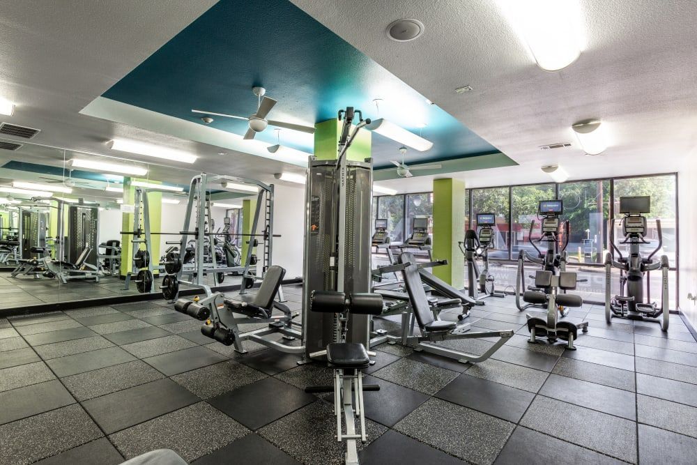 A large gym filled with lots of exercise equipment and mirrors at Regents West at 24th in Austin, TX, near West Campus.
