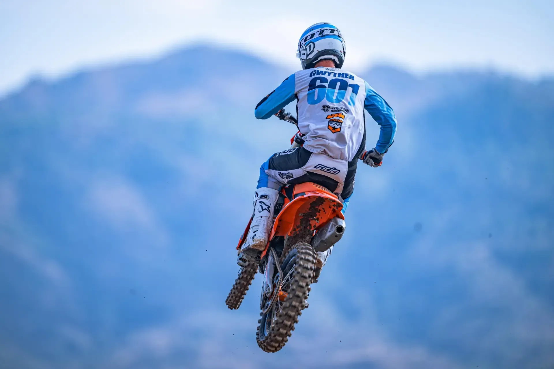 A man is riding a dirt bike in the air.