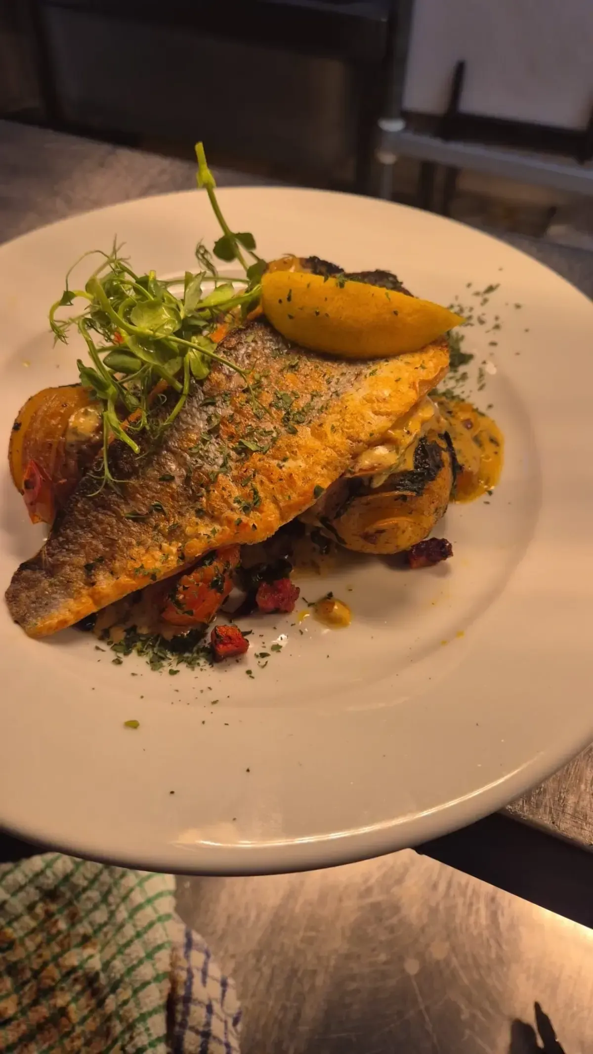 The Mackworth Arms, Laleston, Bridgend | Pan-seared fish on a white plate with lemon, herbs, and potatoes.