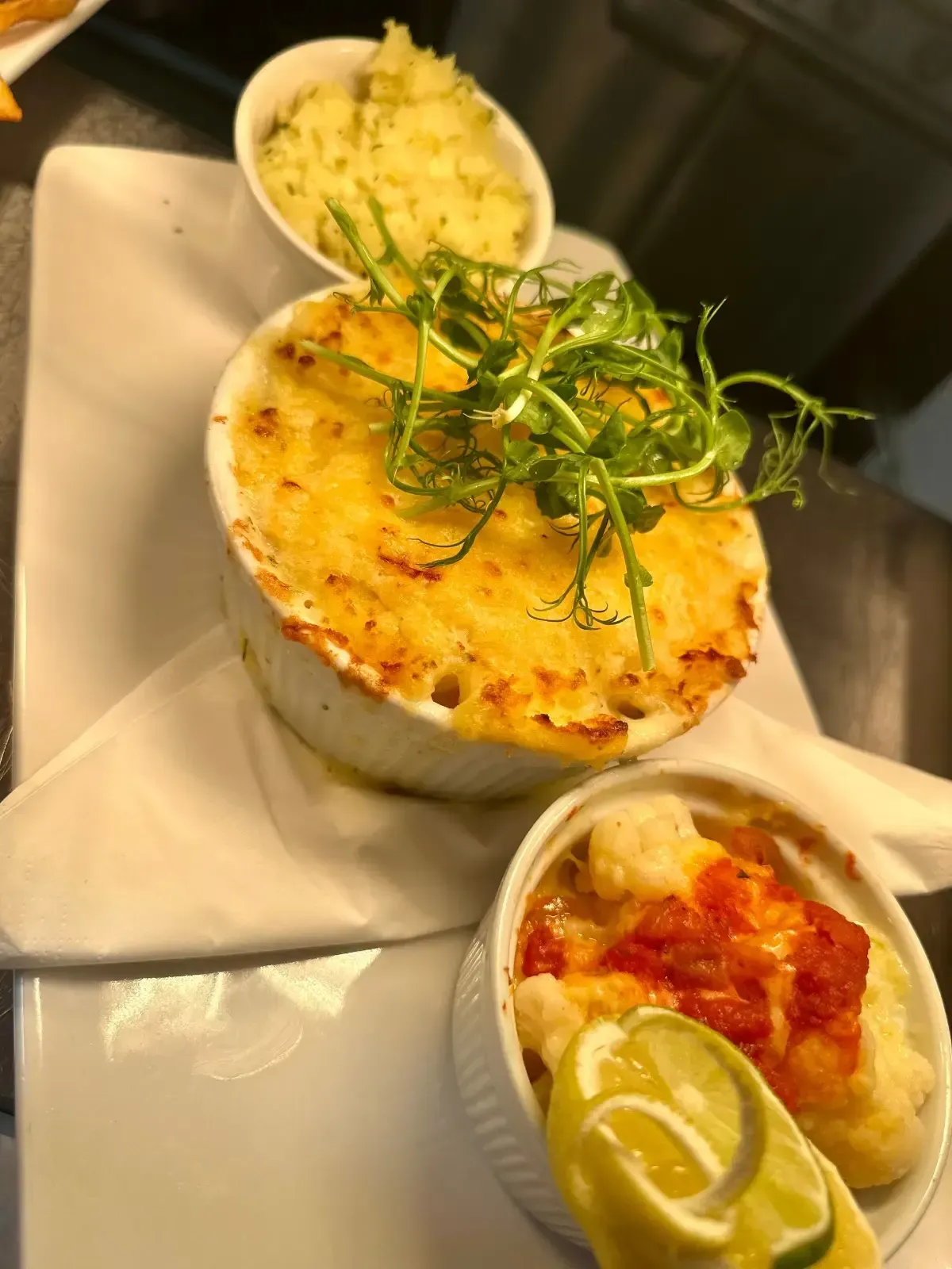 The Mackworth Arms, Laleston, Bridgend | Three ramekins of food on a white plate: fish pie, cauliflower cheese, and mash