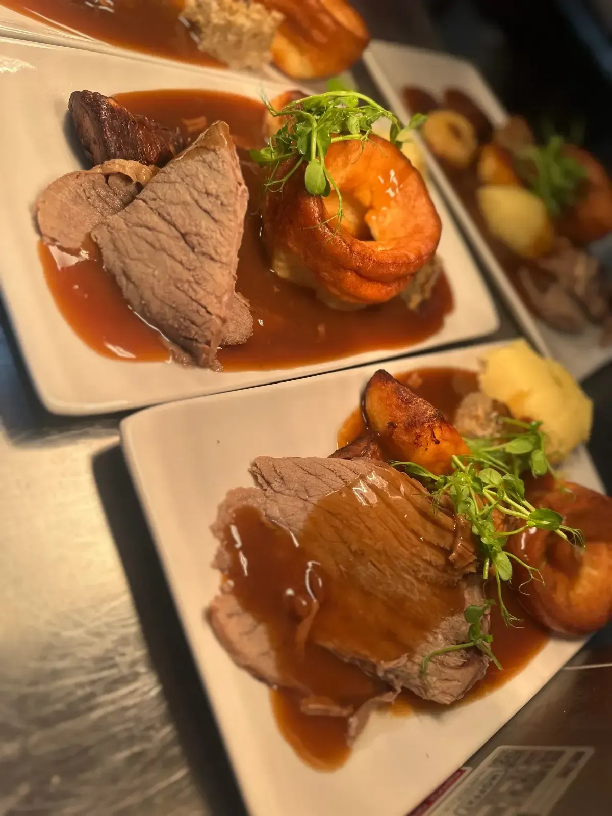 The Mackworth Arms, Laleston, Bridgend | Plates of roast beef with gravy, Yorkshire pudding, and potatoes.