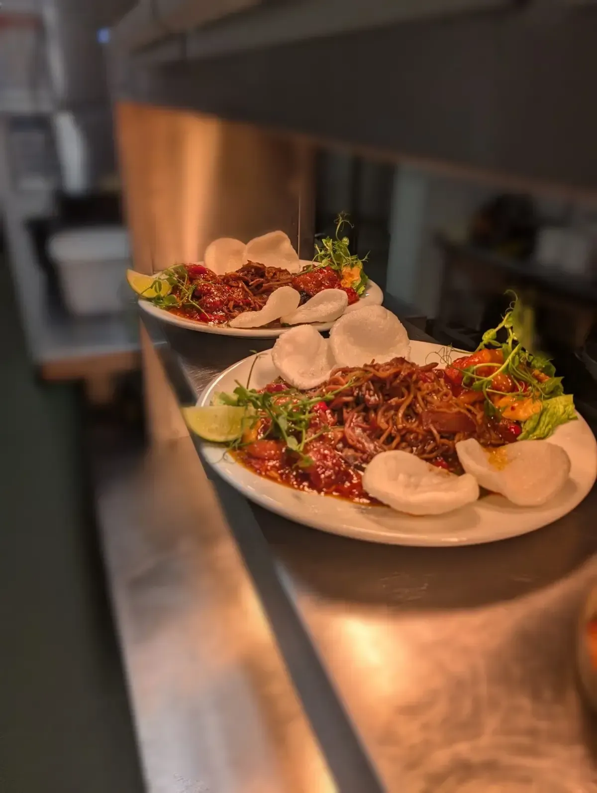 The Mackworth Arms, Laleston, Bridgend | Two plates of food on a stainless steel surface, featuring meat, sauce, garnish, 