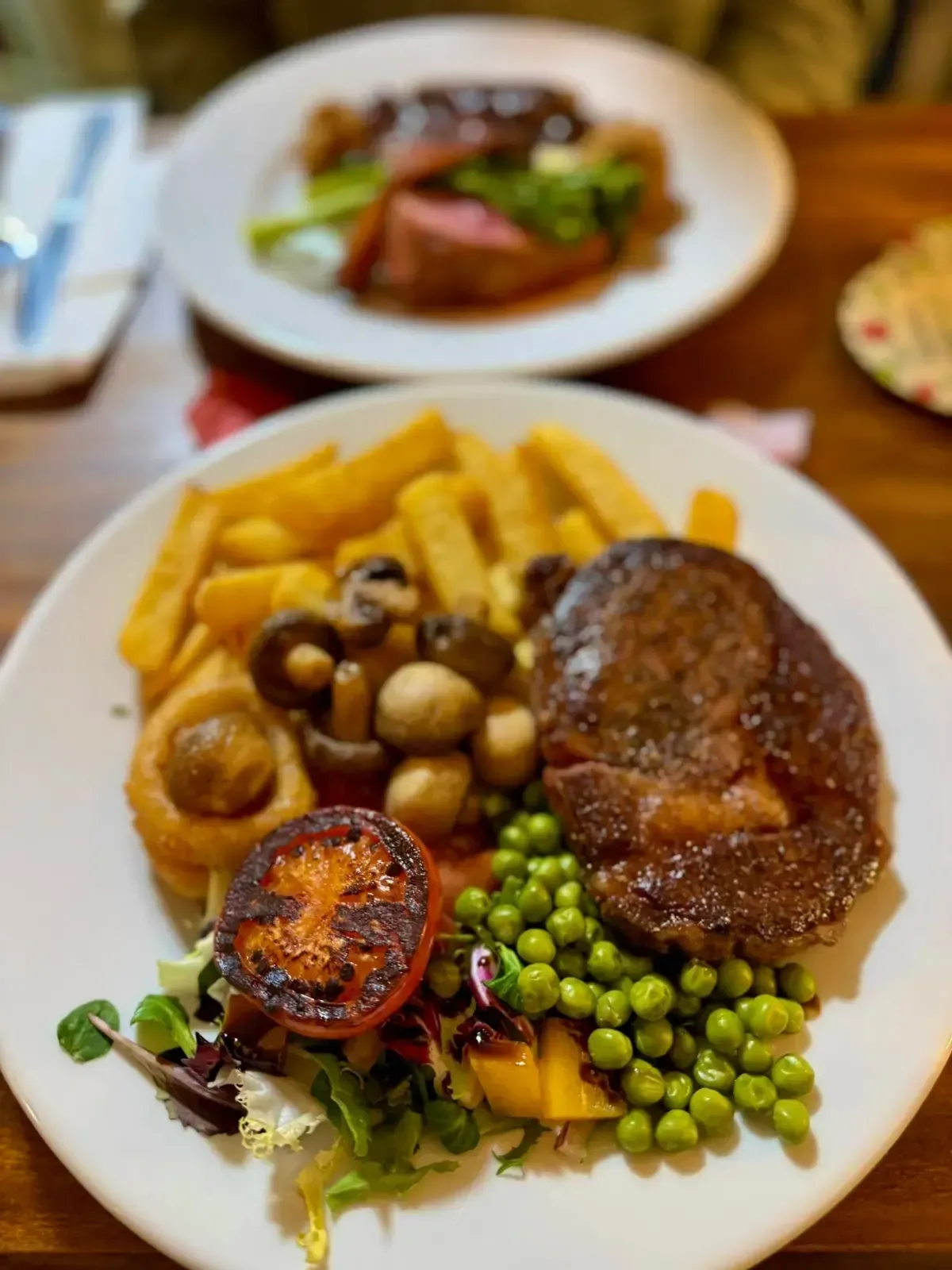 The Mackworth Arms, Laleston, Bridgend | Steak meal on a white plate with chips, peas, mushrooms, tomato, and salad. 