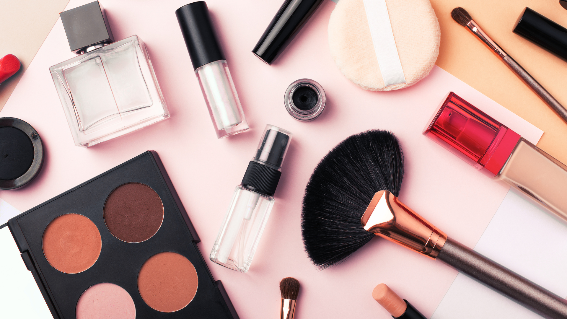 A table topped with a variety of makeup products and brushes.