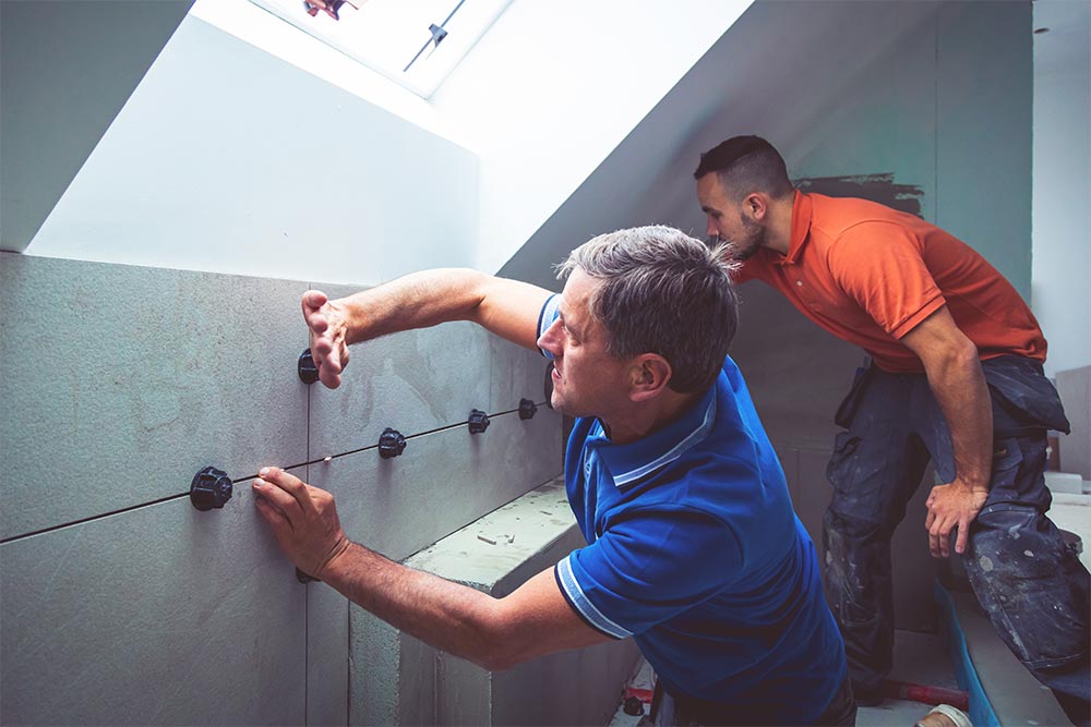 Team Of Tilers Working In A Bathroom
