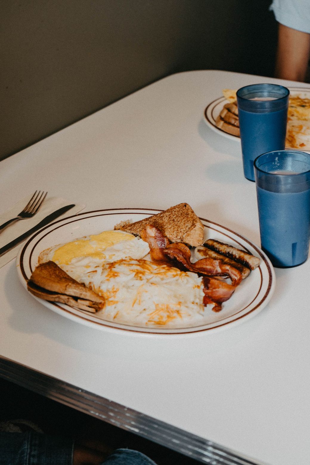 A plate of food with bacon and eggs on a table.