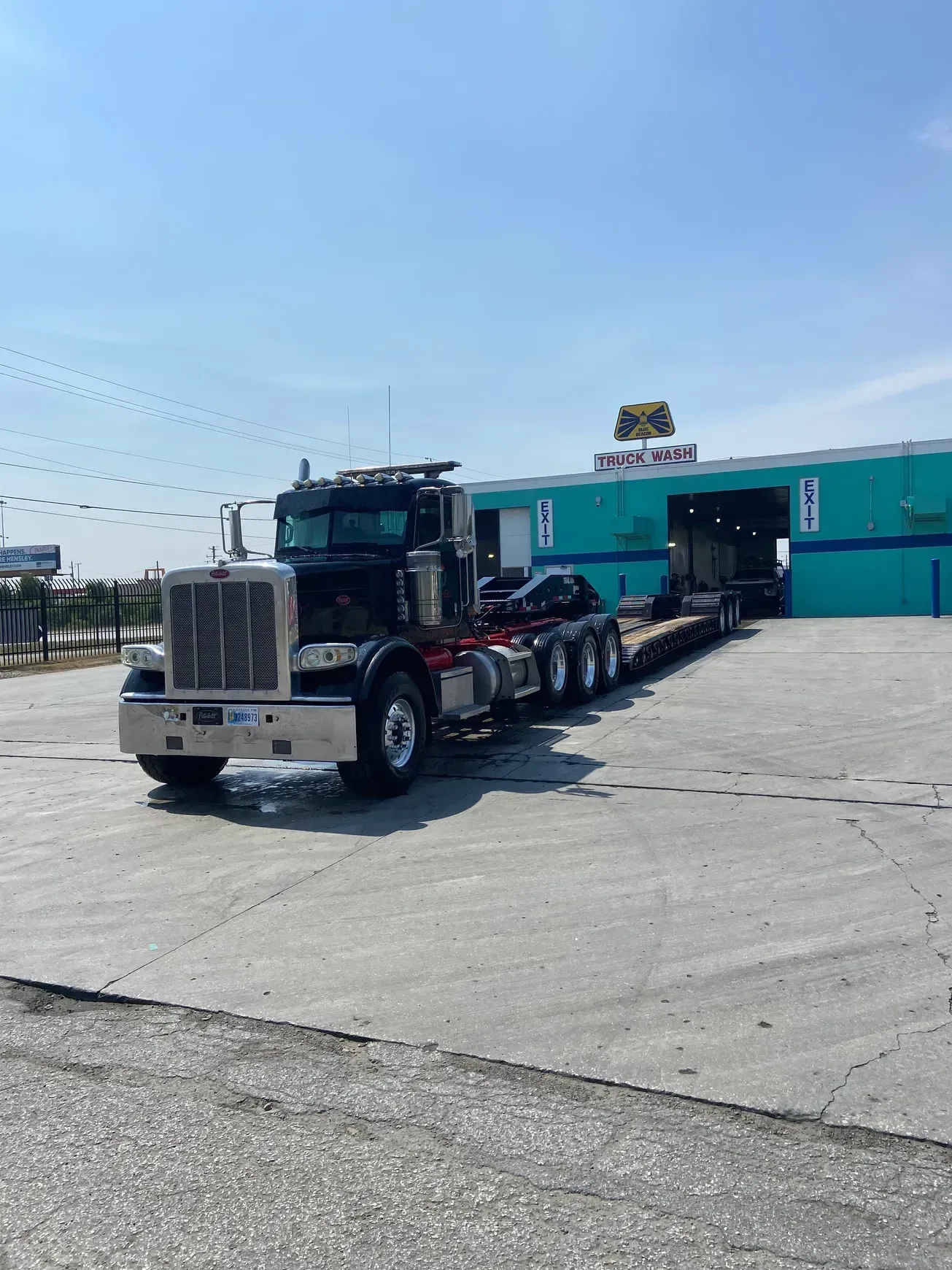 A semi truck is parked in a parking lot in front of a building.