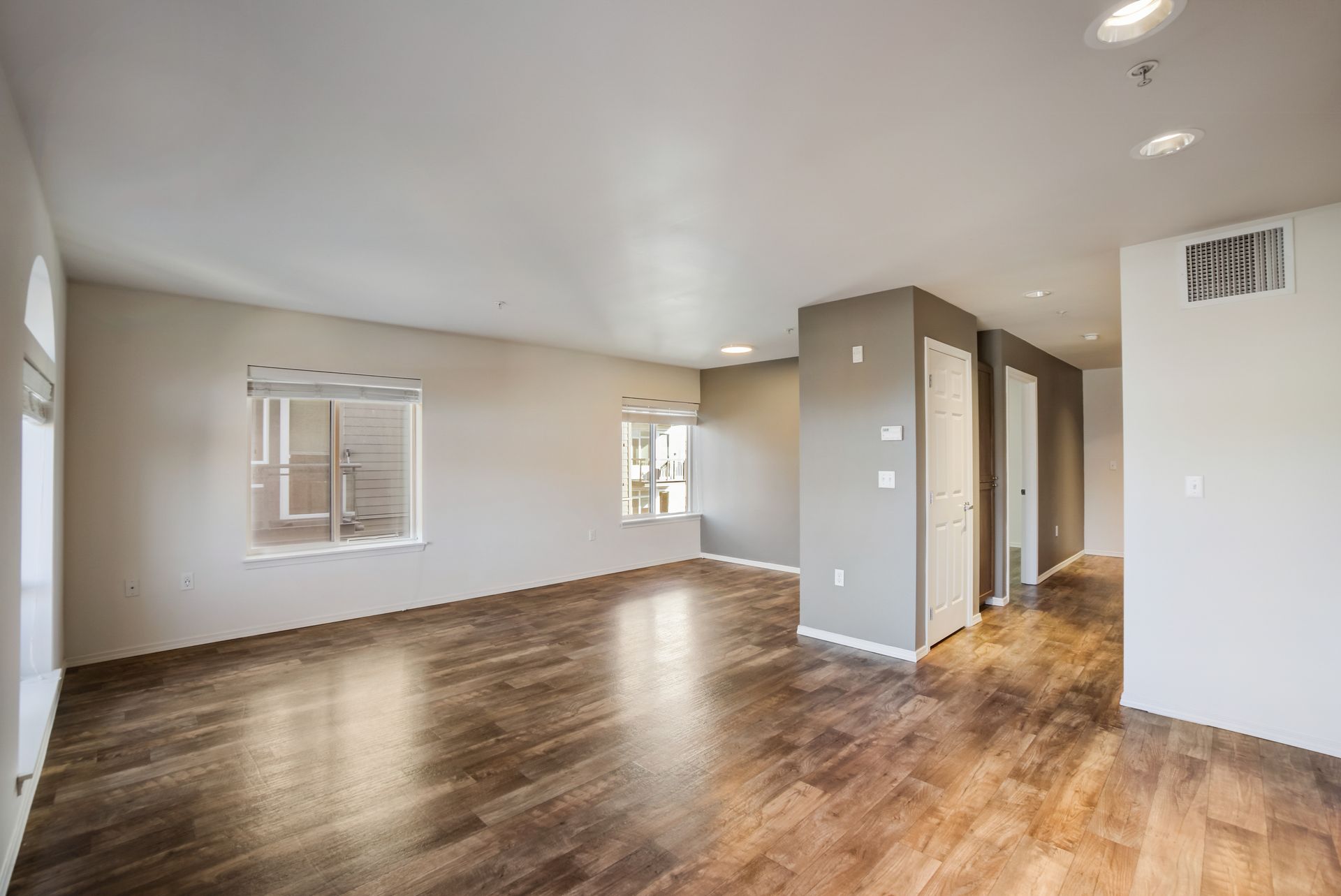 An empty living room with hardwood floors and a window.