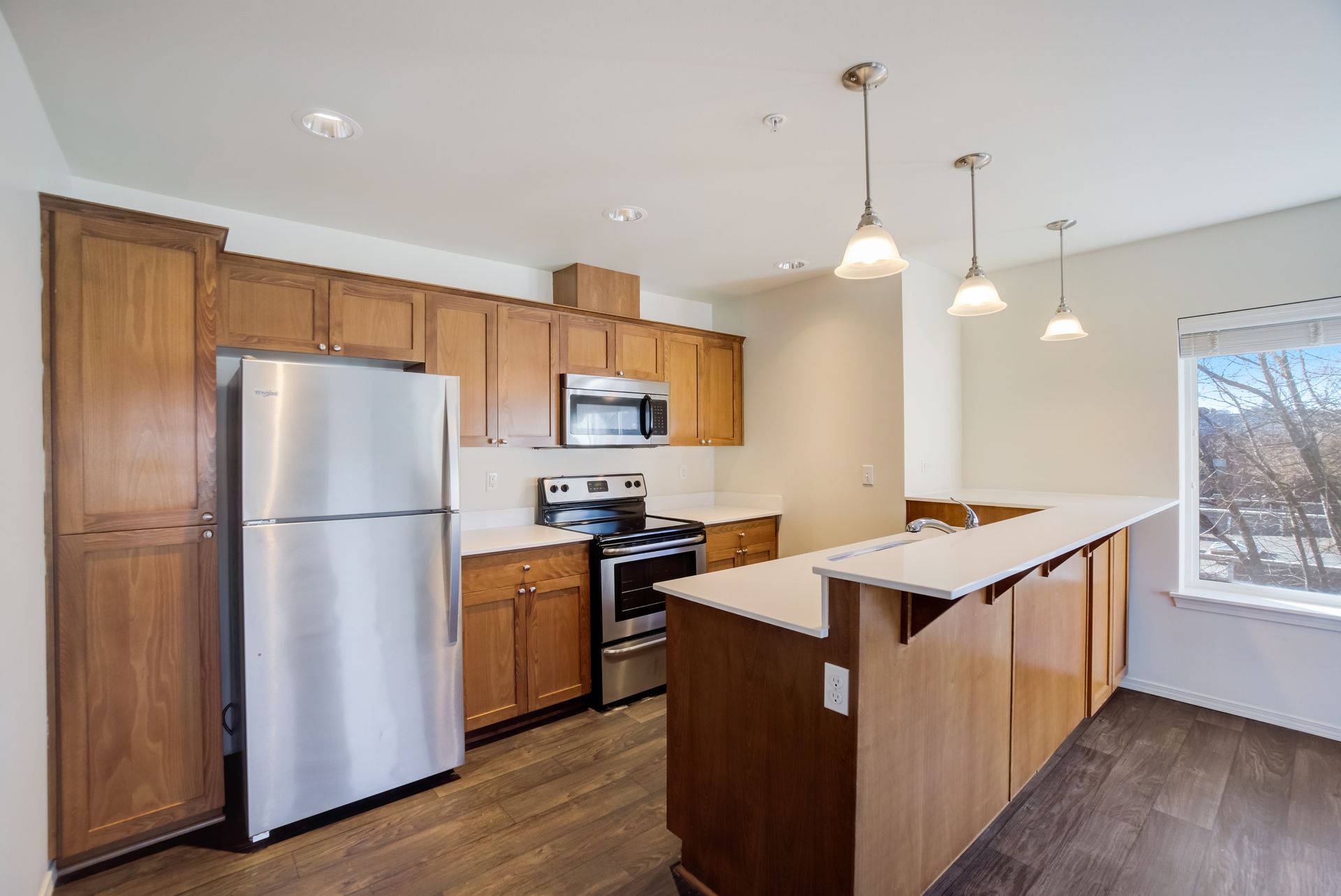 A kitchen with stainless steel appliances and wooden cabinets.