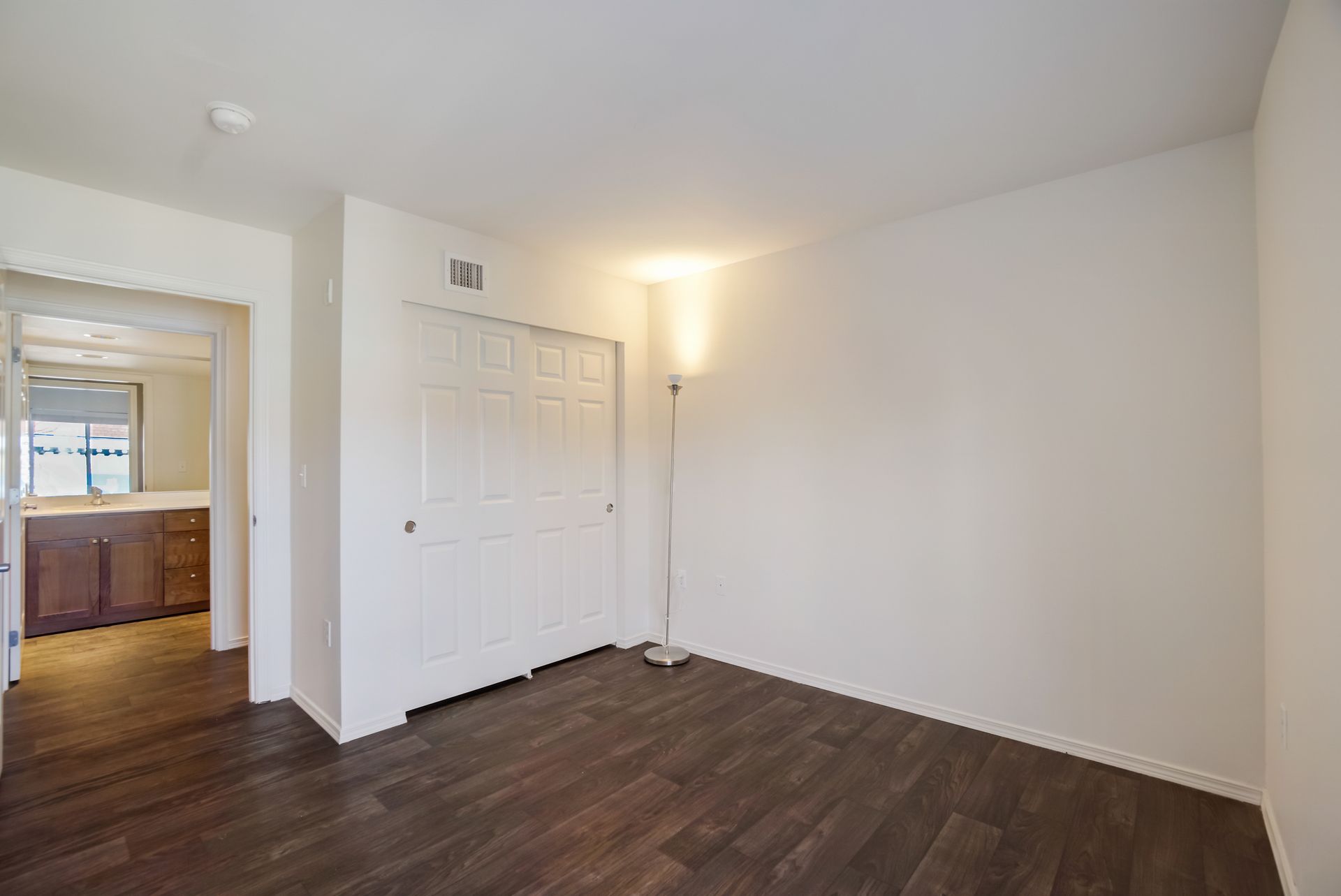An empty room with hardwood floors and white walls.