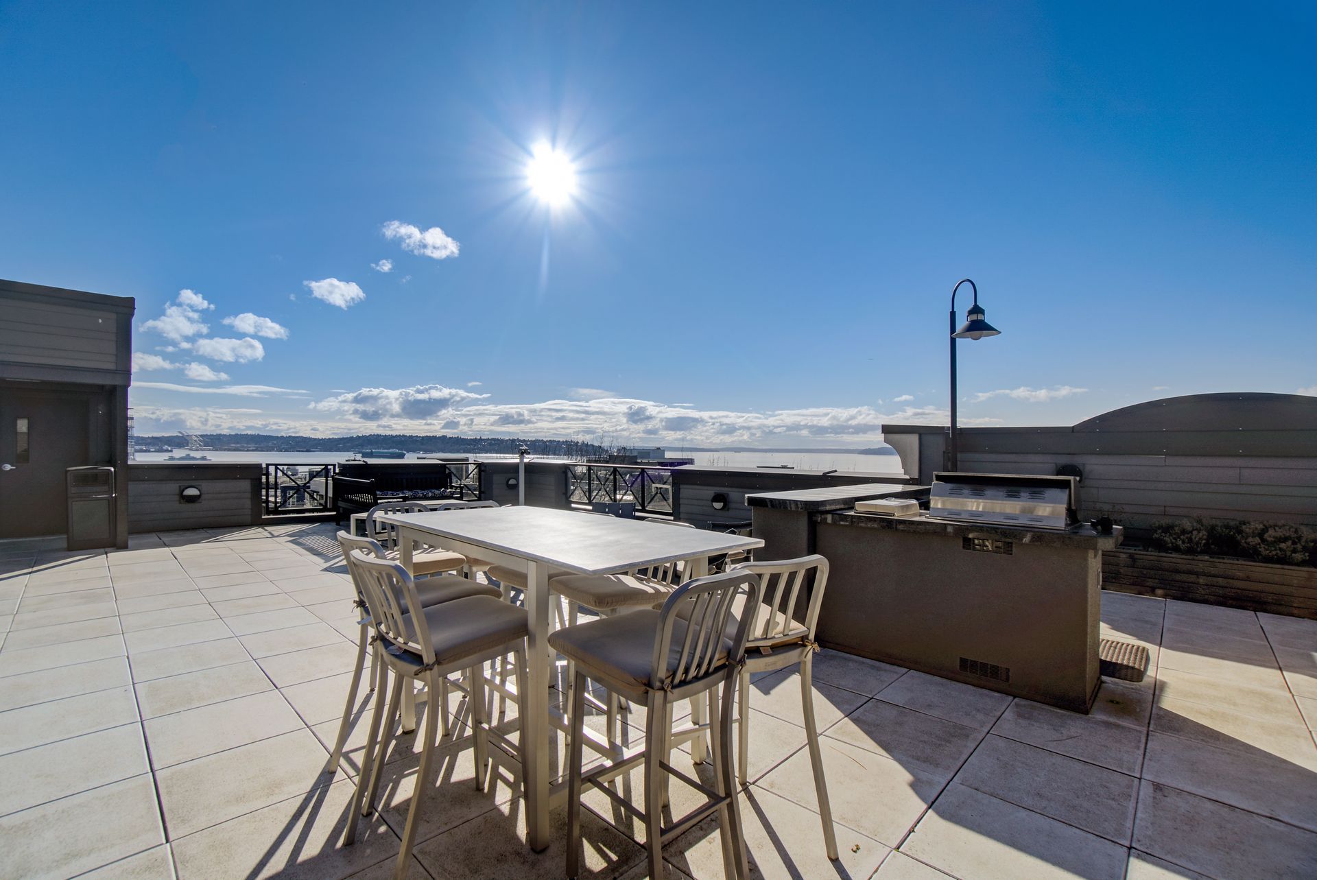 There is a table and chairs on the patio with a view of the ocean.