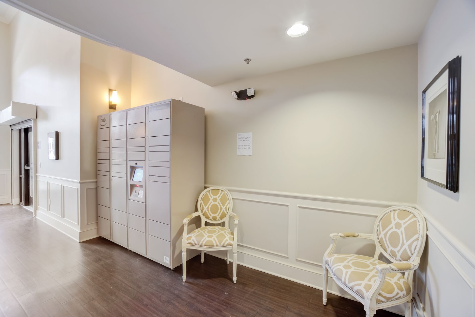 A hallway with two chairs and a locker.
