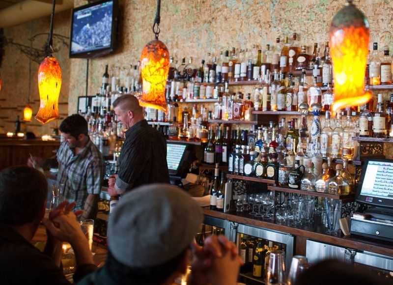 A group of people are sitting at a bar in a restaurant