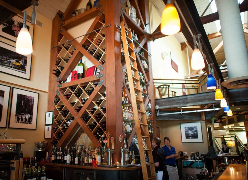 A restaurant with a ladder leading up to a wine rack