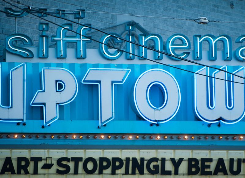 A blue and white sign for a cinema called uptown
