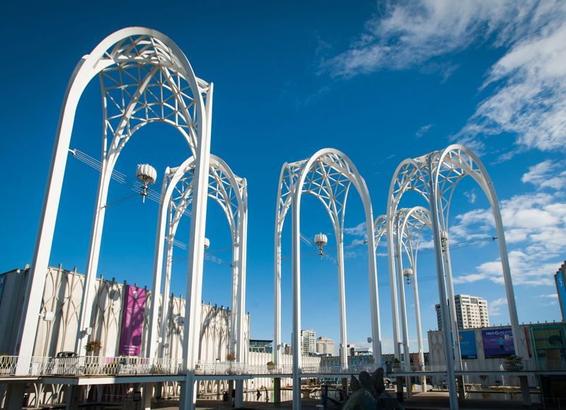 A row of white arches against a blue sky