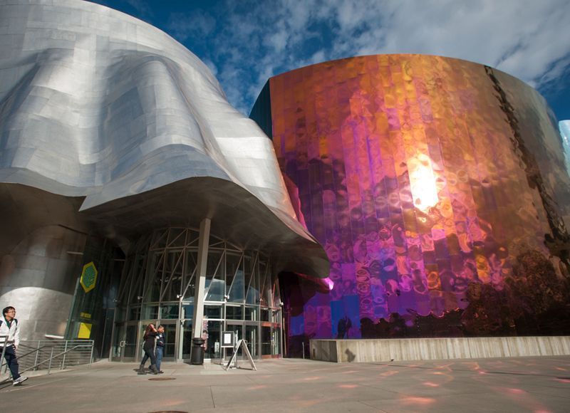 A group of people are walking in front of a large building.