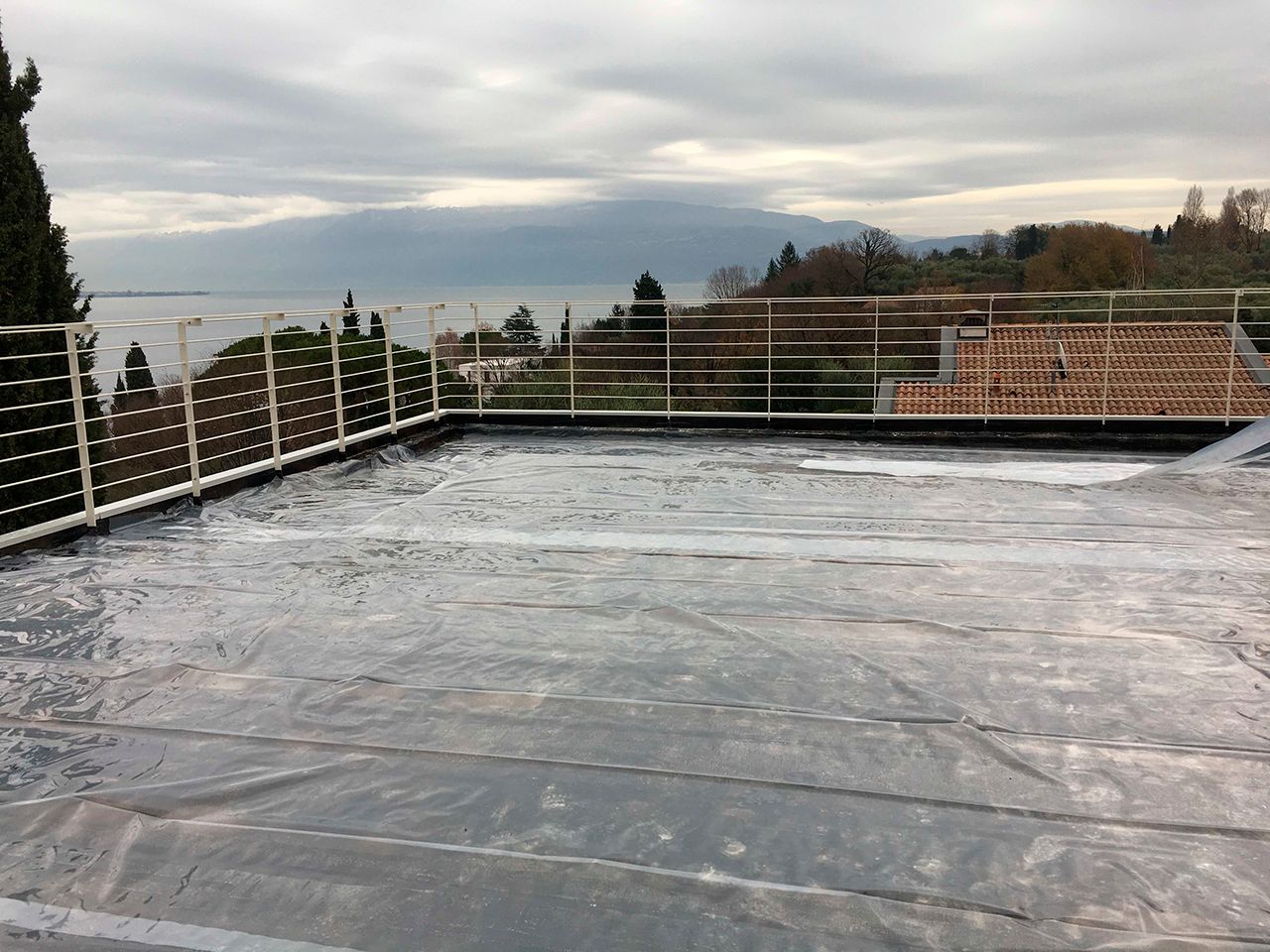 un tetto con un telo di plastica sopra e una ringhiera.