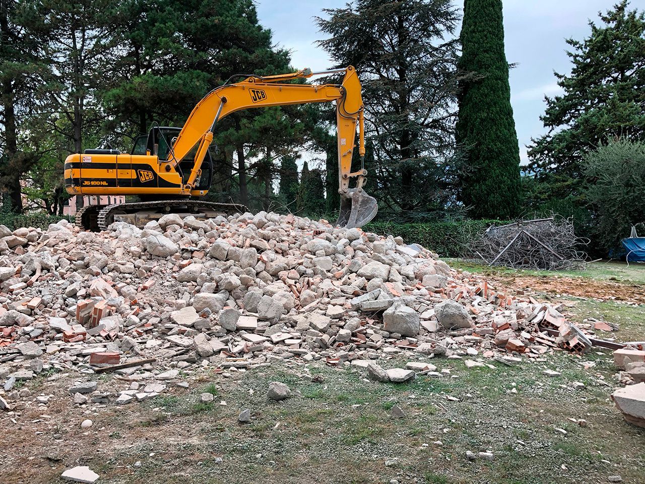 Un escavatore giallo sta lavorando su un mucchio di rocce.