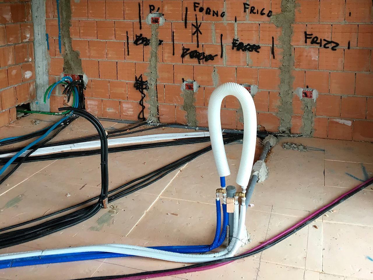 un mucchio di fili sono collegati a un muro di mattoni