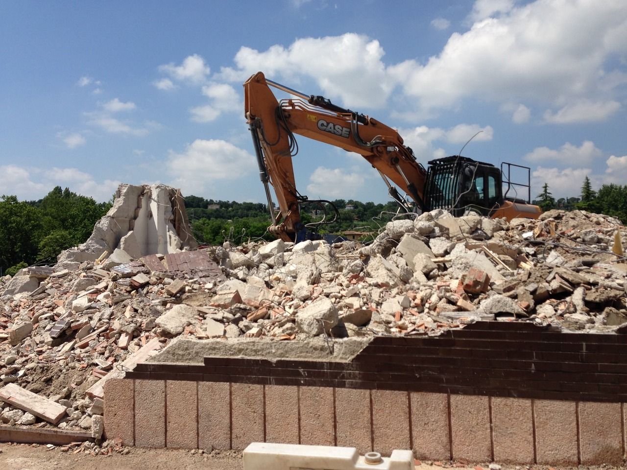 un escavatore sta lavorando su un cumulo di macerie