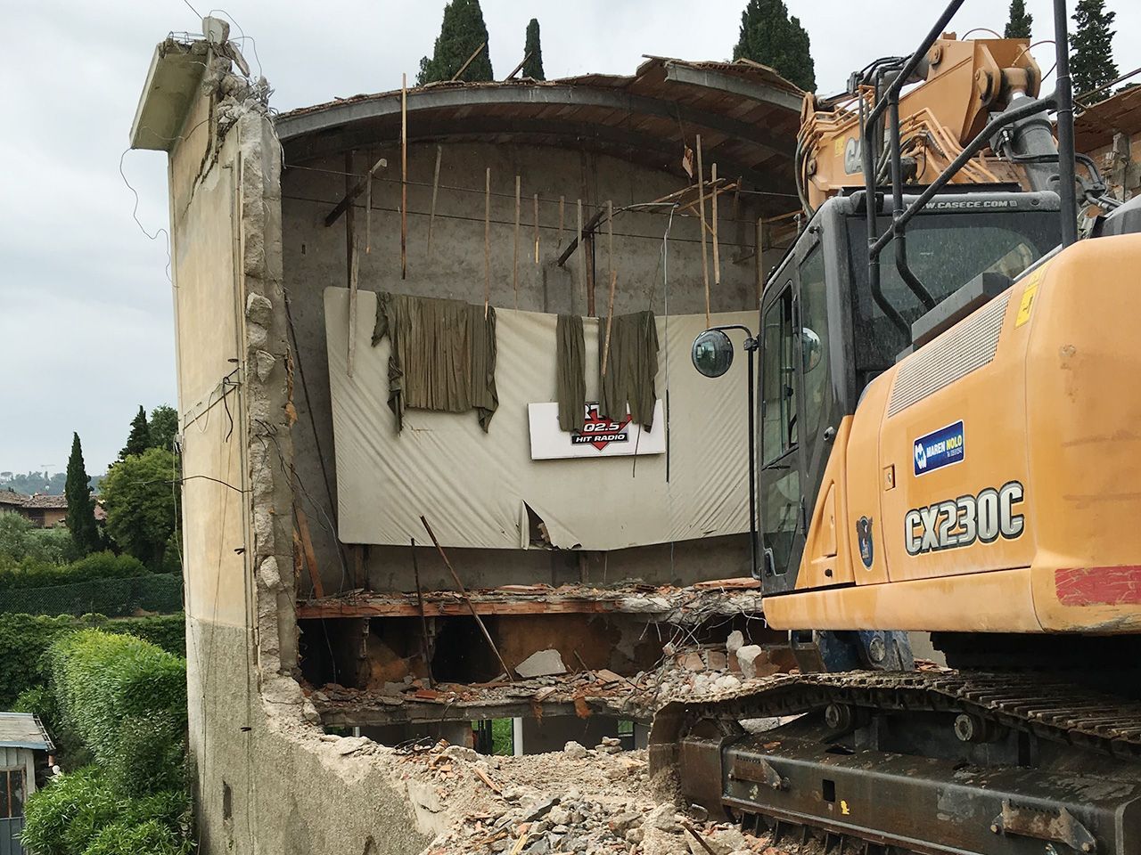 un grande escavatore giallo sta demolendo un edificio.