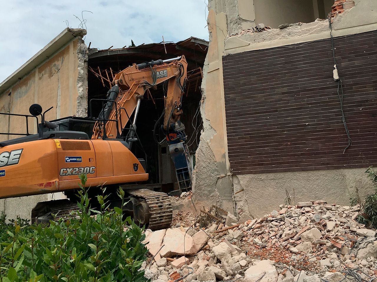 un escavatore sta demolendo un edificio
