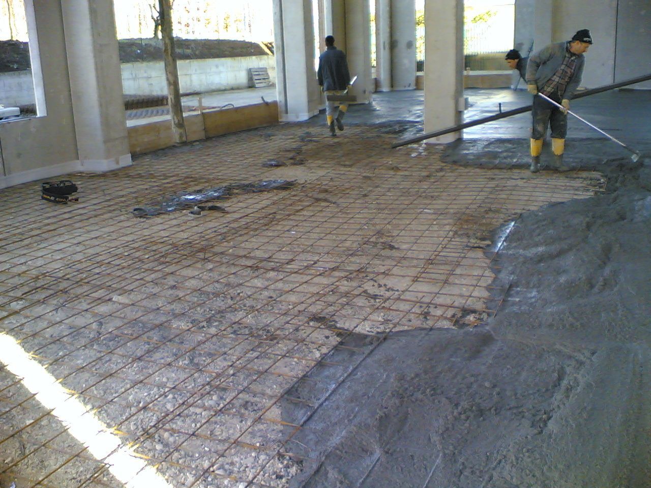 Un uomo sta stendendo del cemento su un pavimento di mattoni