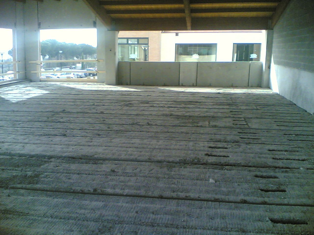 una stanza vuota con un pavimento di cemento e un balcone