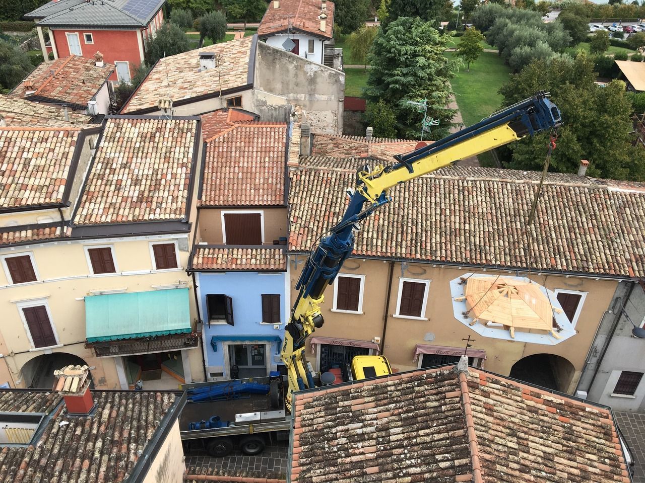 Una veduta aerea di una gru in cima a un edificio. Recupero e restauro Campanile