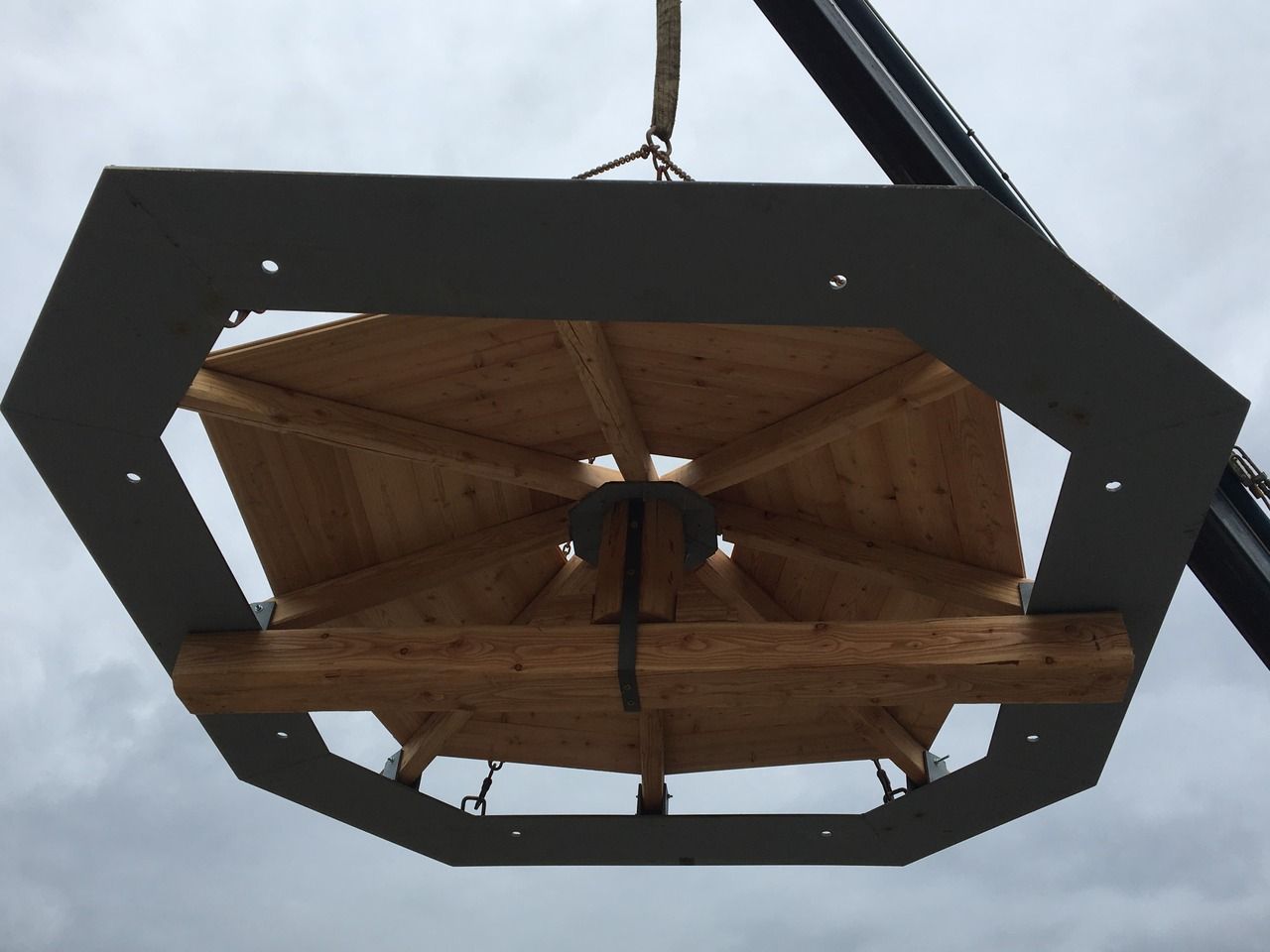 una struttura in legno viene sollevata da una gru