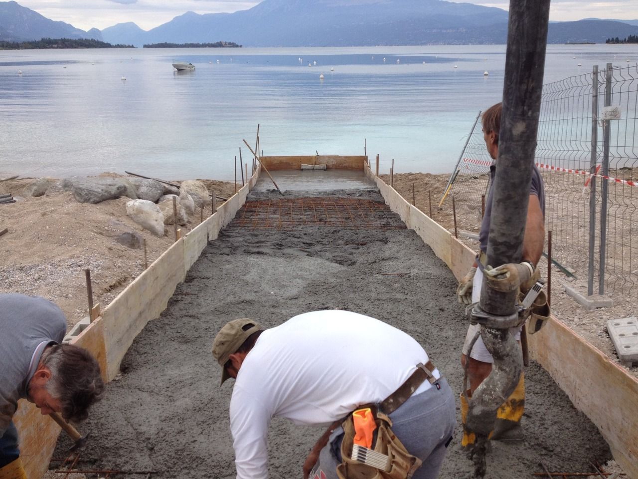 un gruppo di operai edili sta lavorando su una spiaggia per realizzare uno scivolo