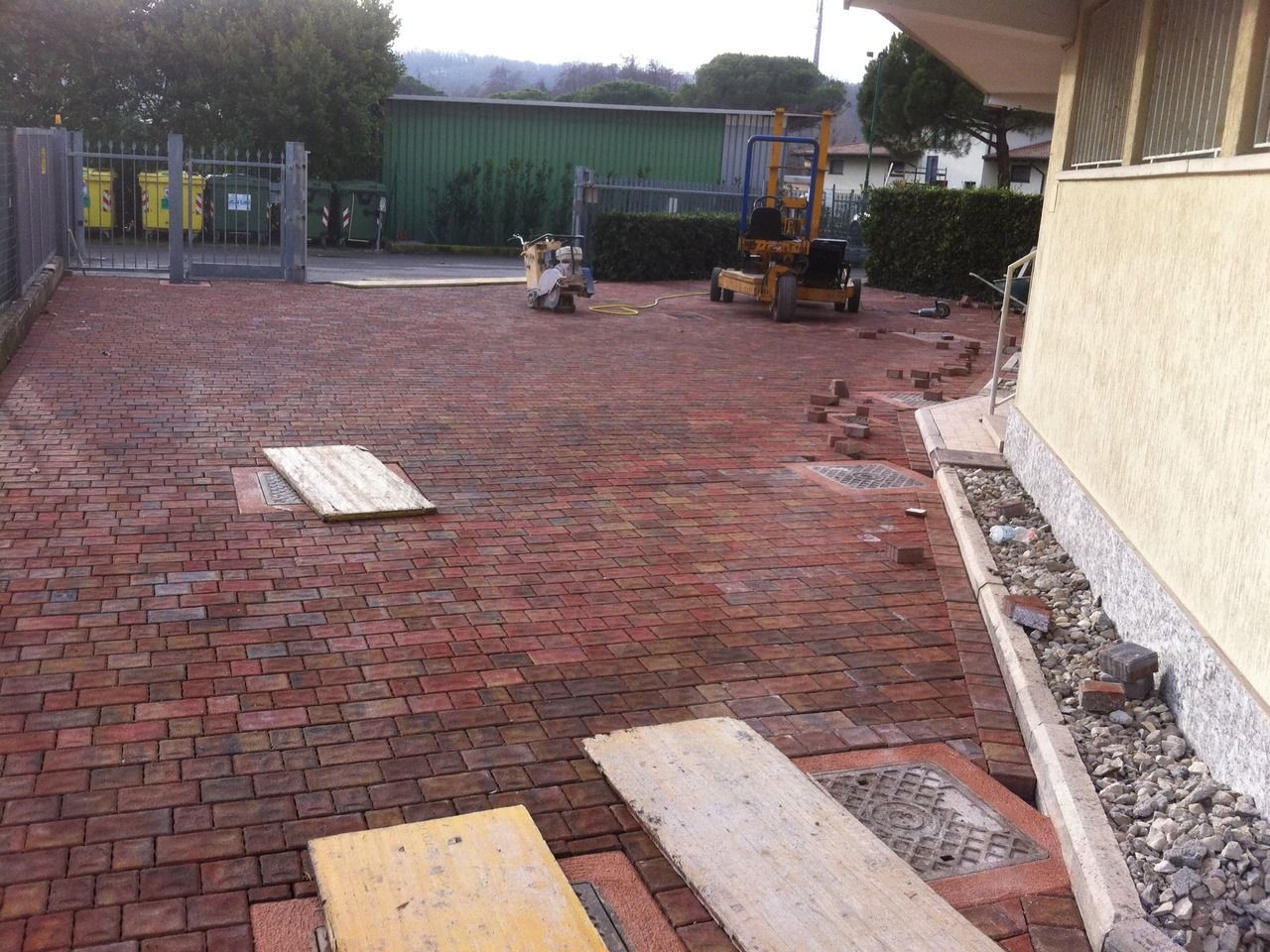 Un vialetto di mattoni con un carrello elevatore giallo sullo sfondo