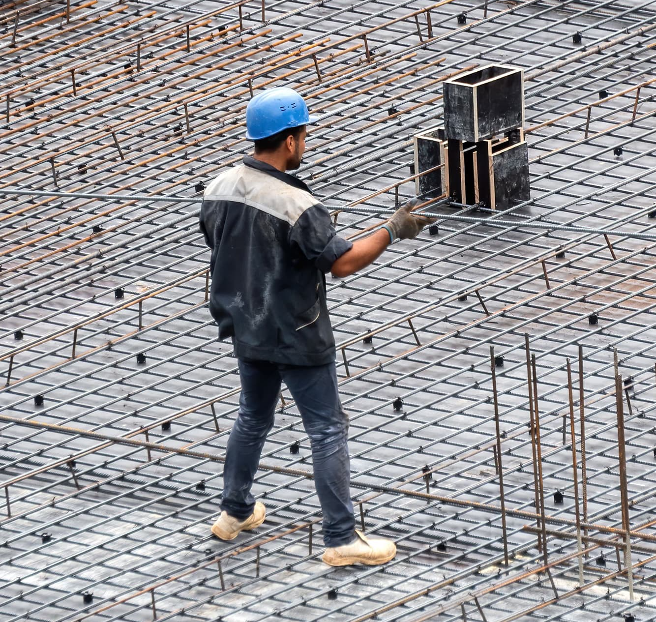 un operaio edile cammina su un pavimento di cemento.