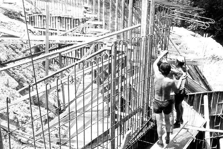 una foto in bianco e nero di due uomini in piedi su un ponte.