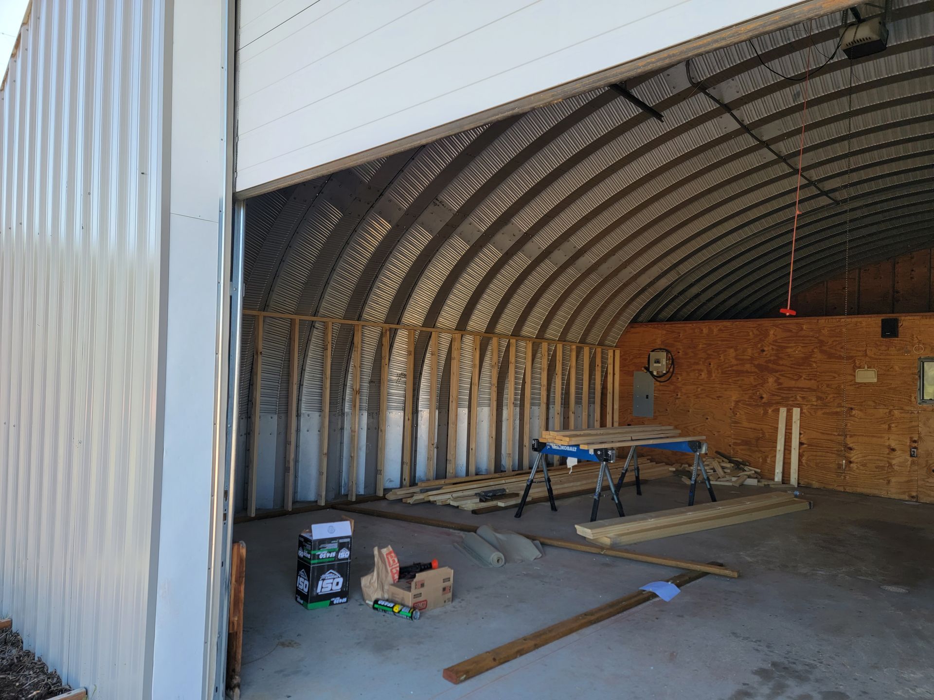 A garage under construction with a table and boxes on the floor