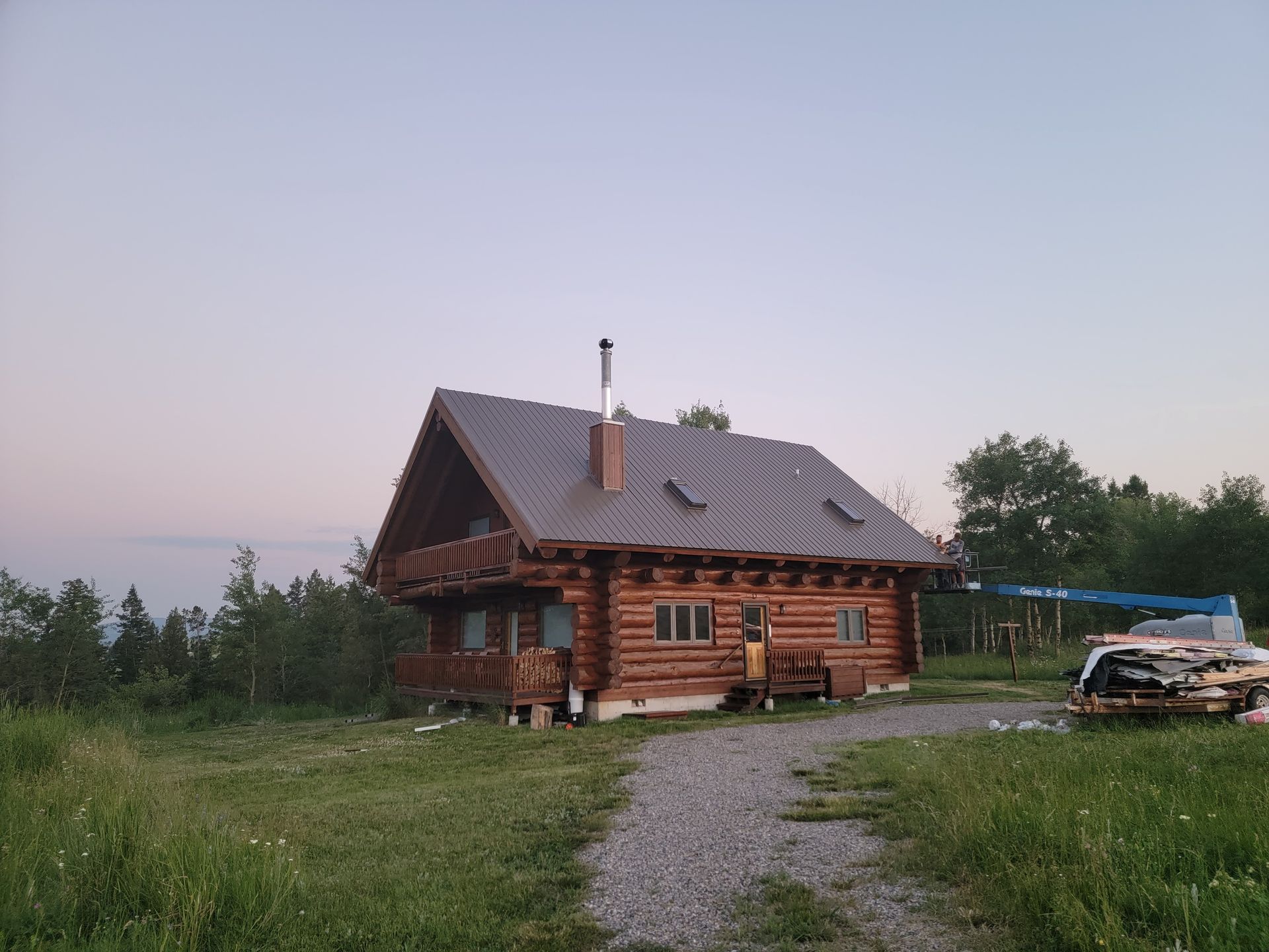 A log cabin is sitting in the middle of a grassy field.