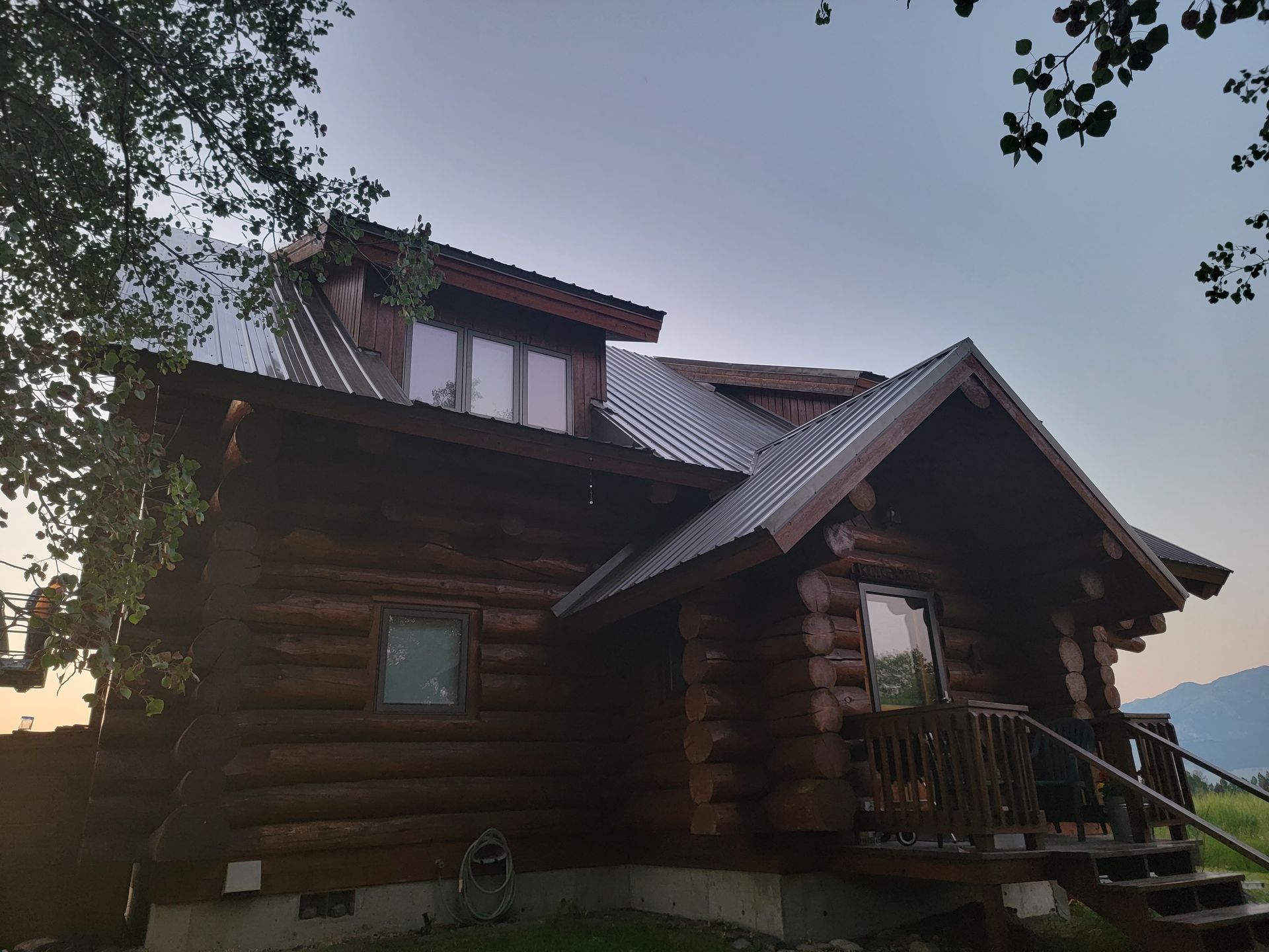 A log cabin with a metal roof and stairs