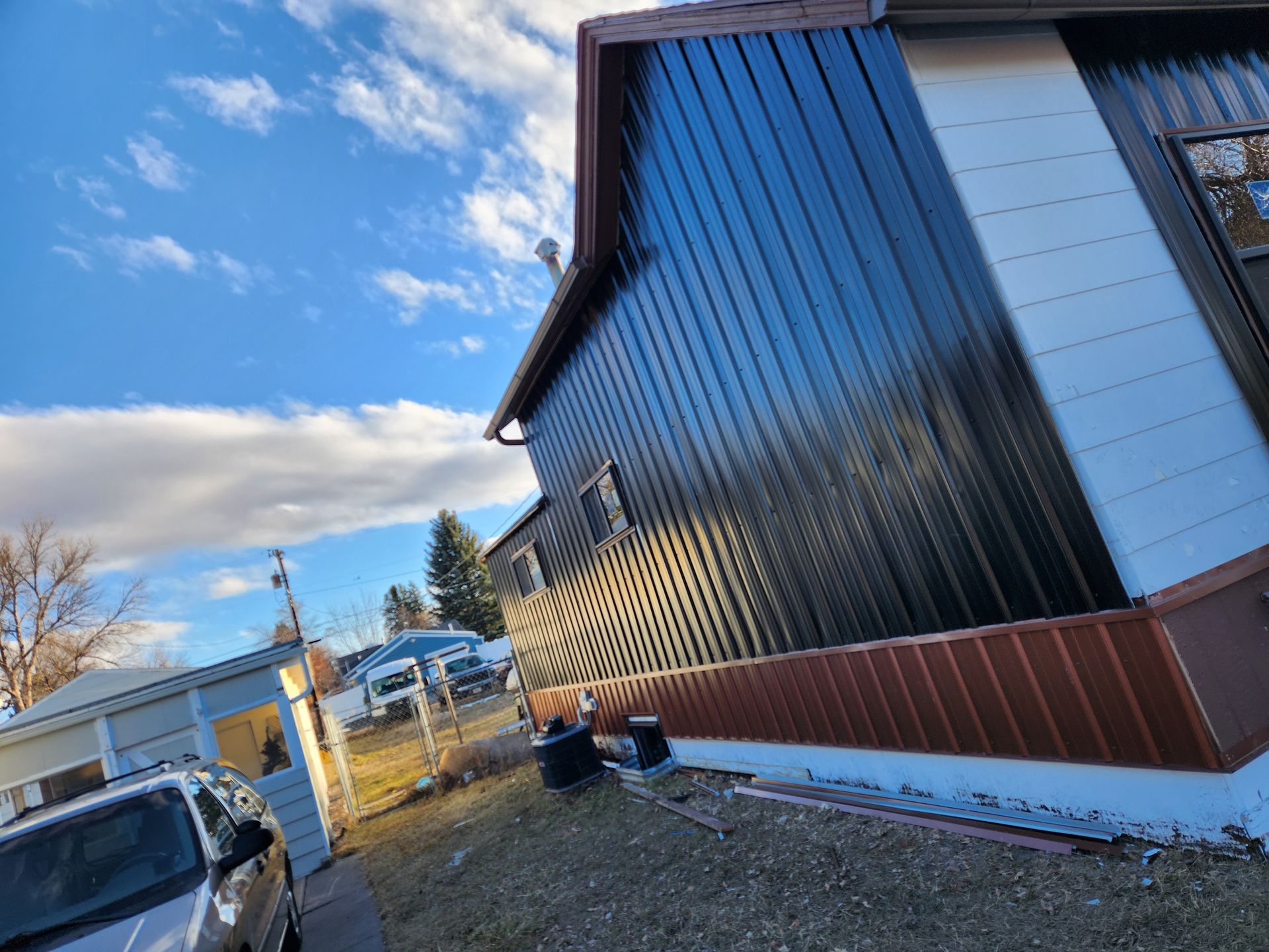 A black and white house with a car parked in front of it.