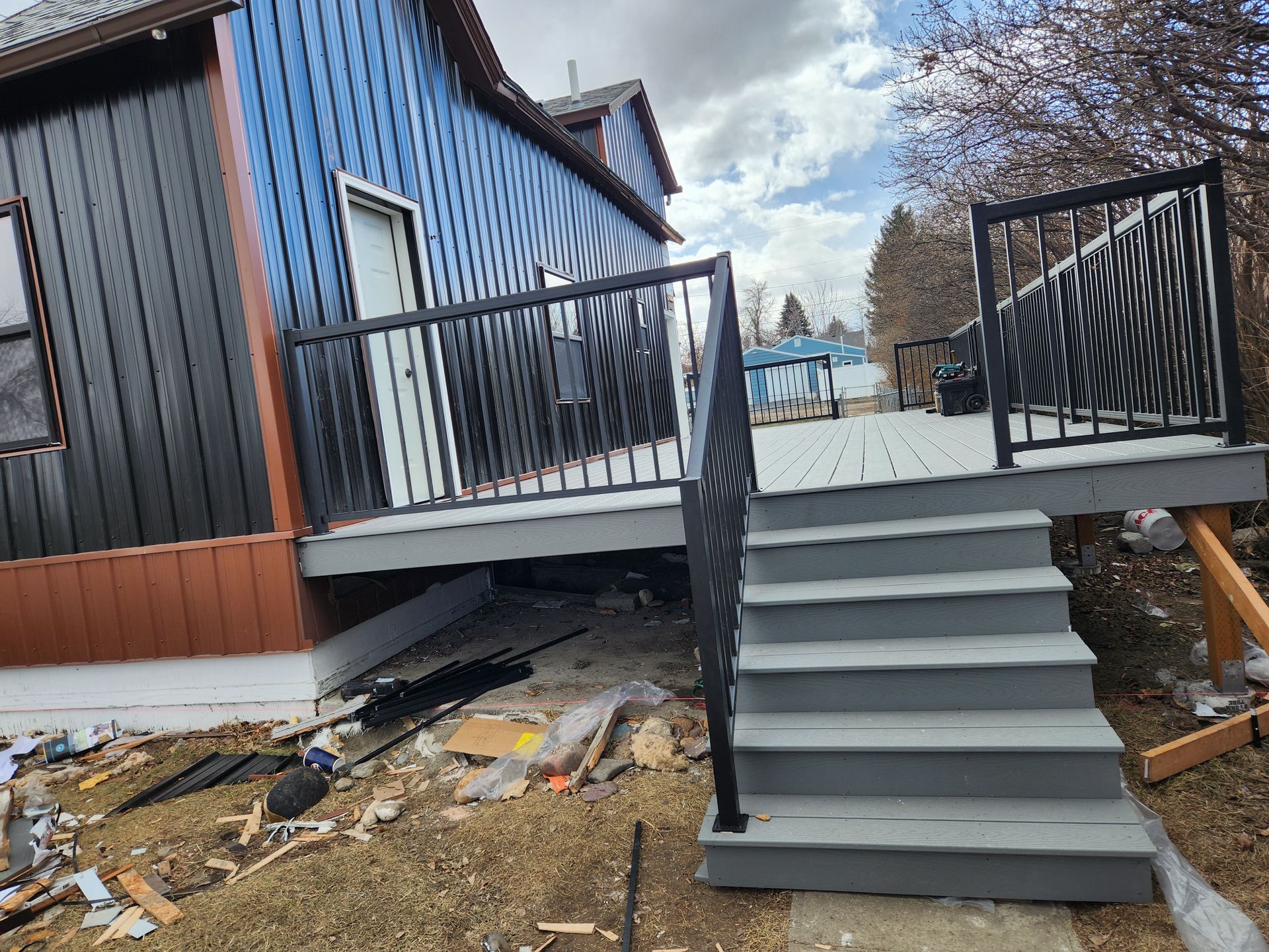 A house with a deck and stairs in front of it.