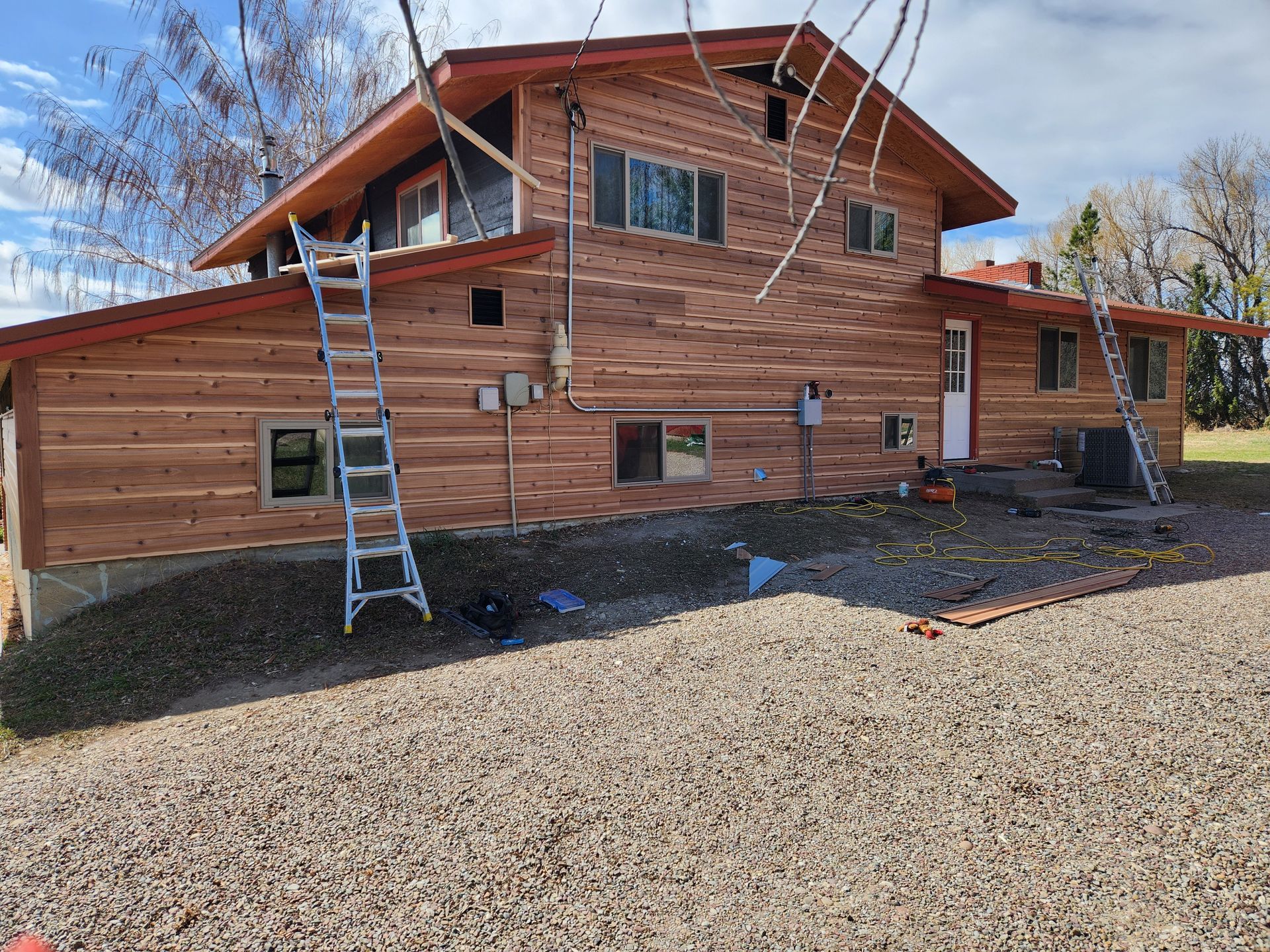 A large wooden house with a ladder on the side of it.