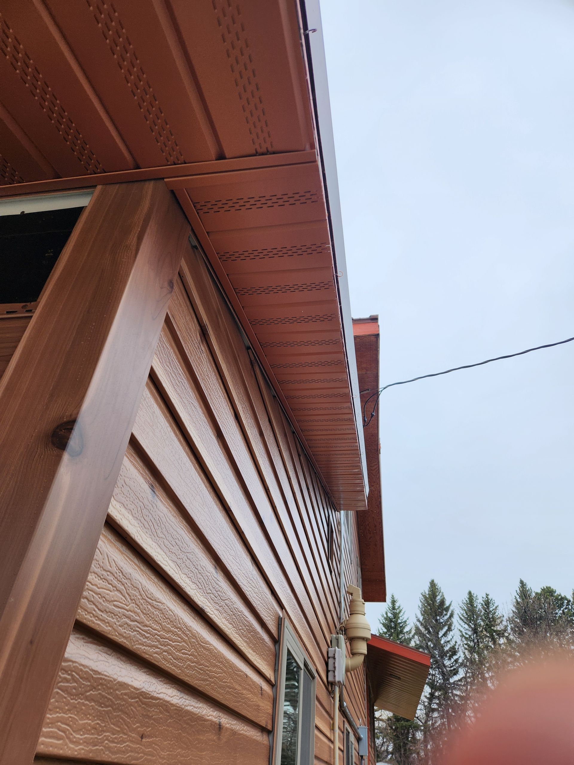 A close up of a wooden house with a red roof.