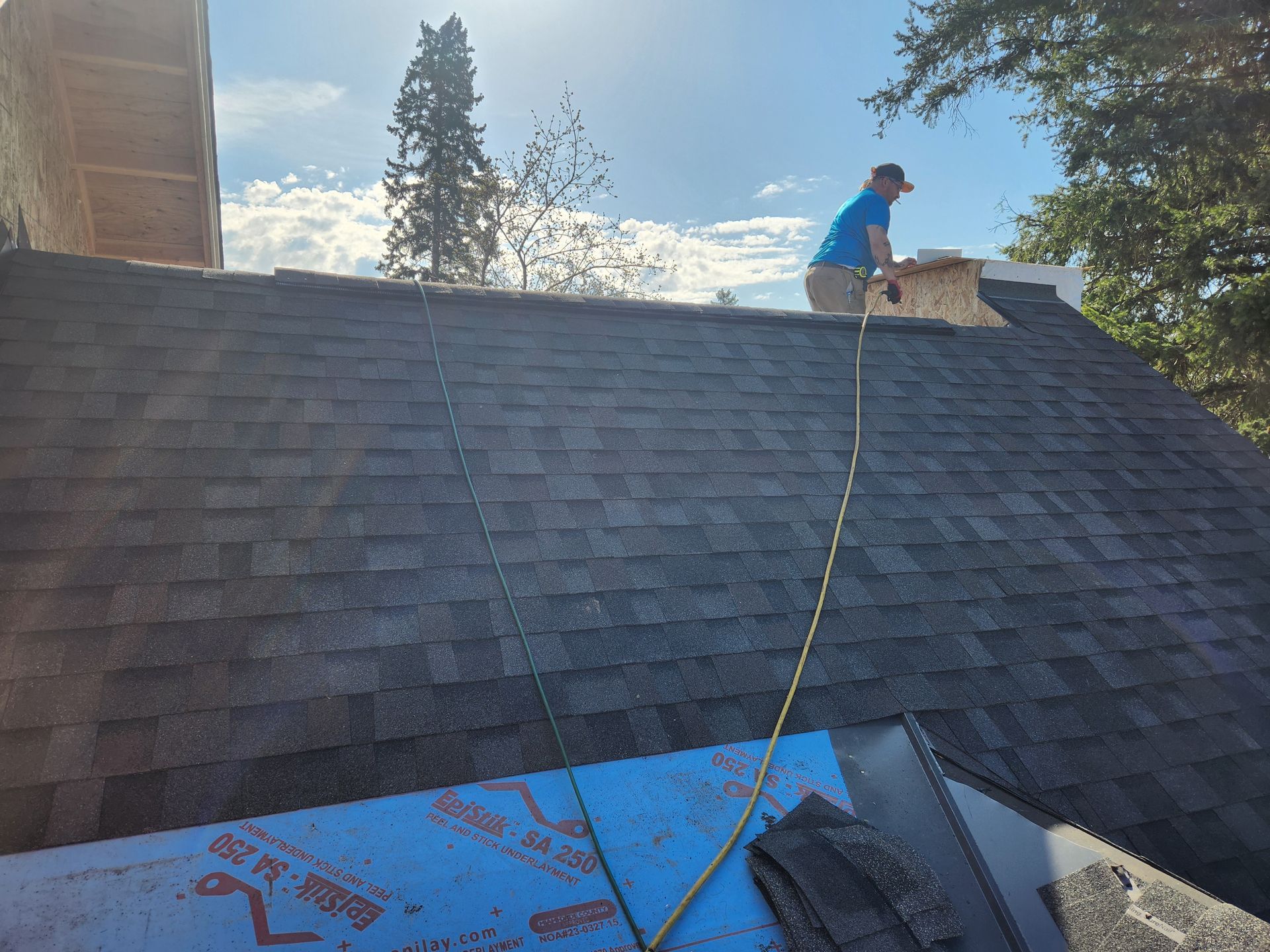 A man is standing on top of a roof.
