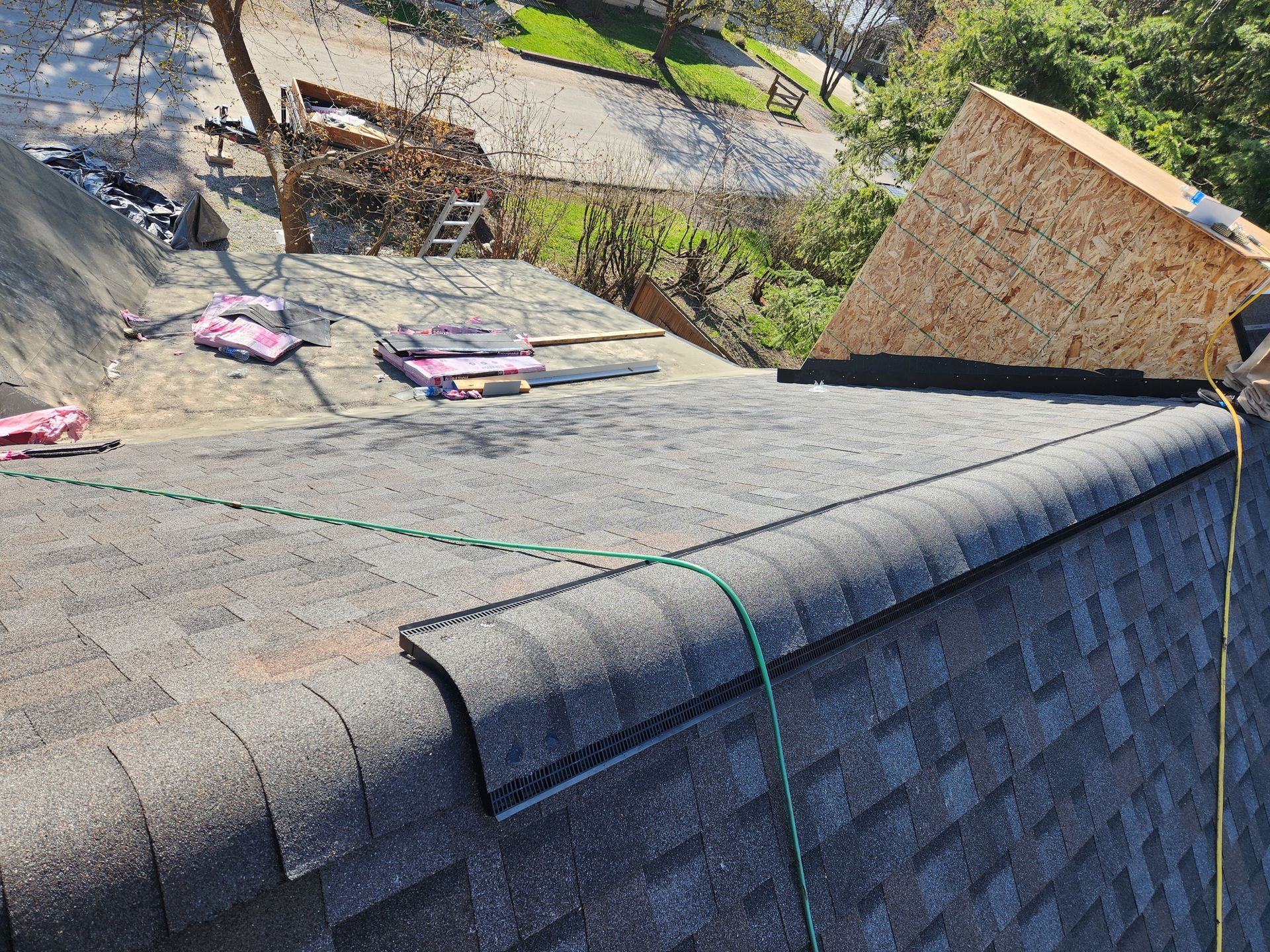 A roof with shingles being installed on it is being worked on.