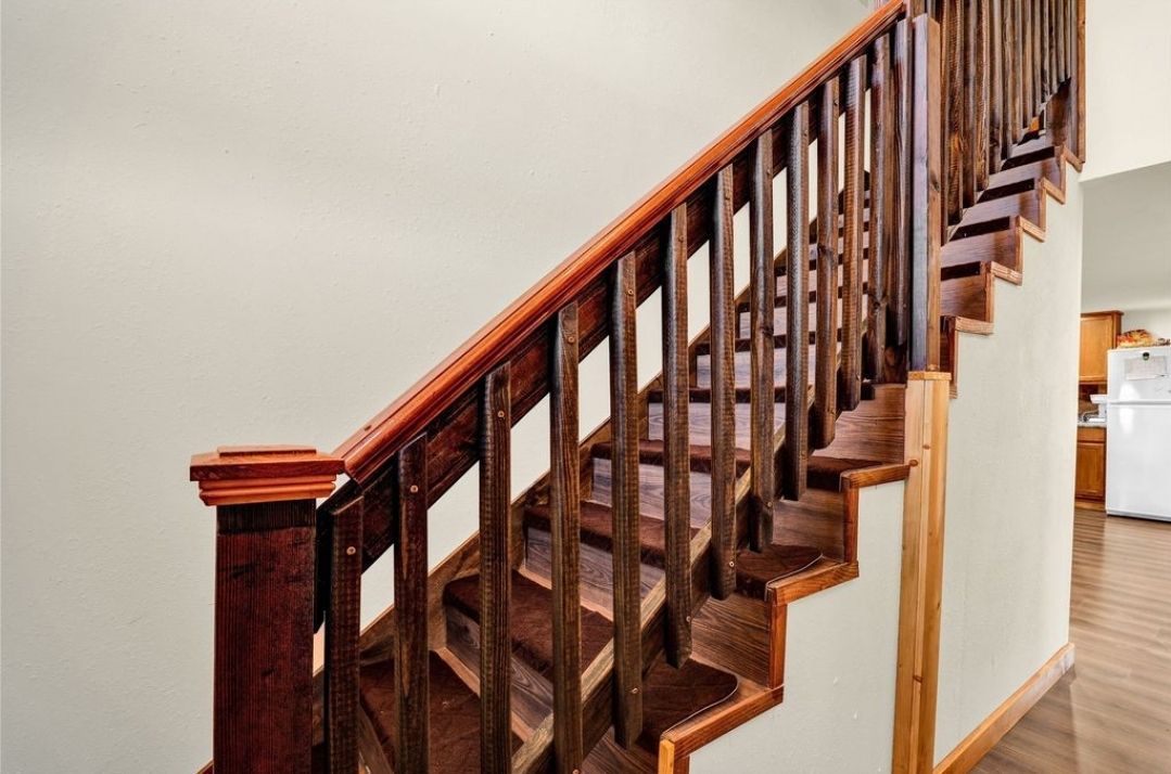 A wooden staircase with a wooden railing in a house