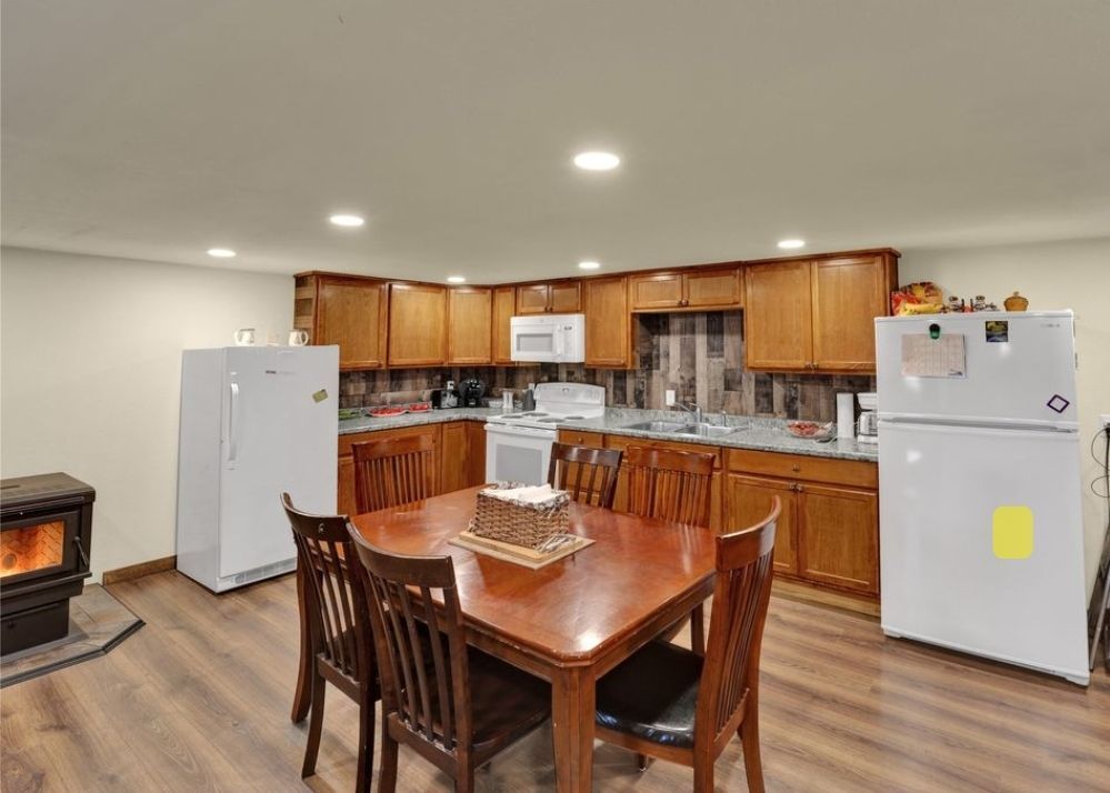 A kitchen with a table and chairs and a refrigerator.