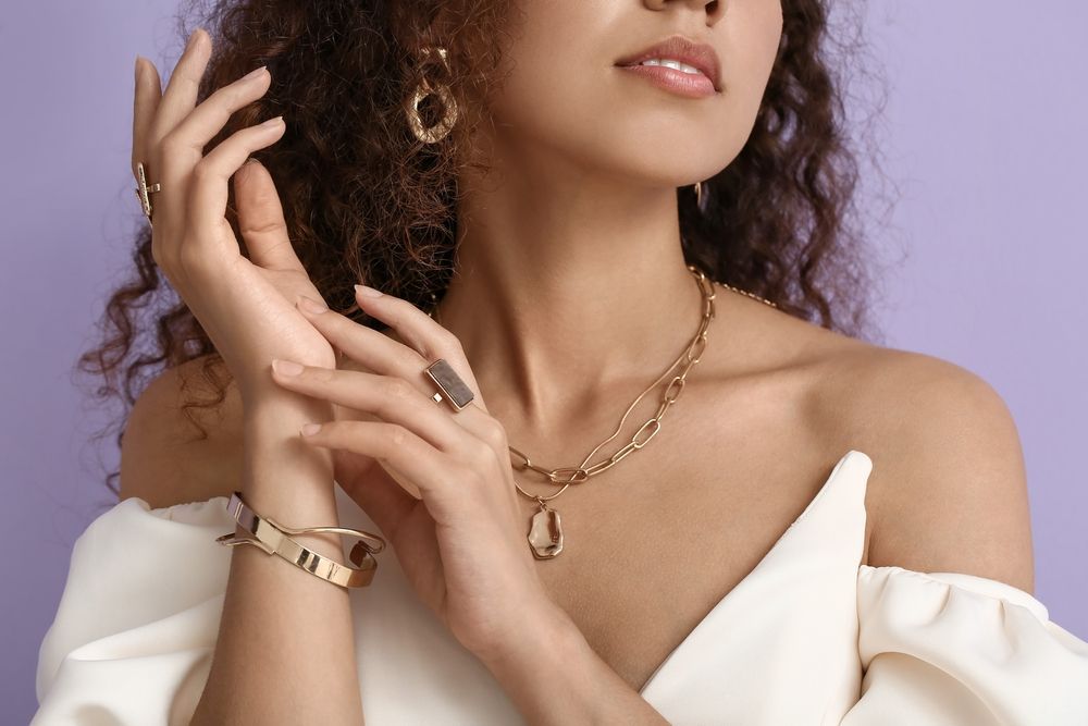 A woman is wearing a necklace , earrings , and a bracelet.