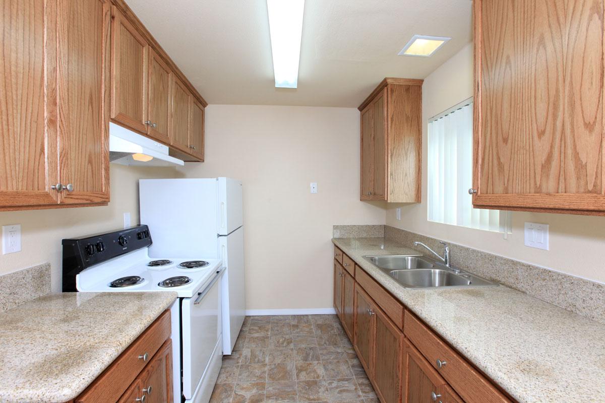 Full kitchen with wood cabinets and an electric stove.